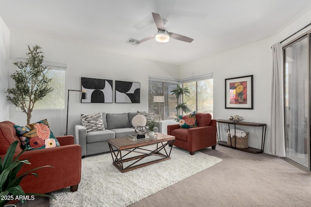 carpeted living room with ceiling fan