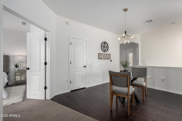 dining space featuring a notable chandelier and dark hardwood / wood-style flooring