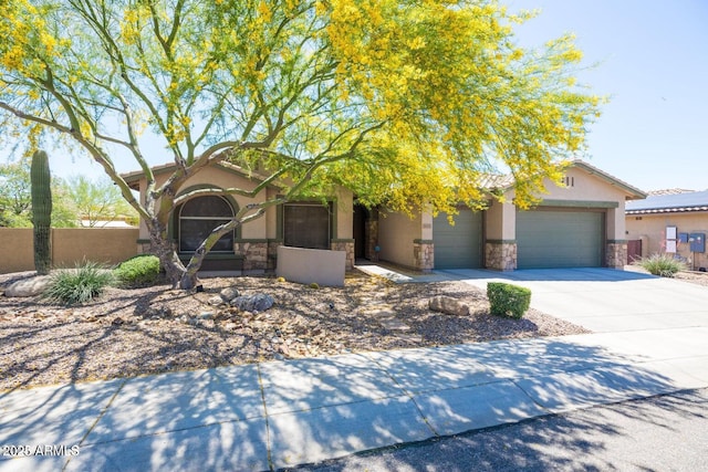 view of front of house featuring fence, driveway, an attached garage, stucco siding, and stone siding