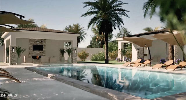 view of swimming pool with an outdoor stone fireplace, a patio, and ceiling fan