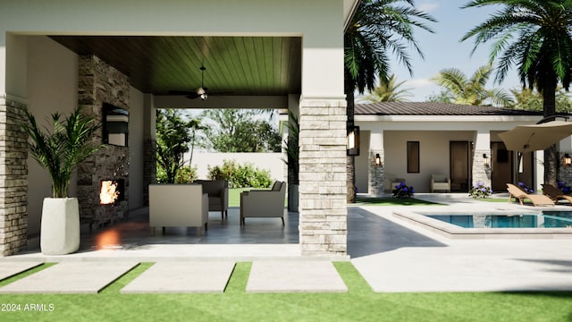 exterior space featuring ceiling fan, an outdoor stone fireplace, and a patio