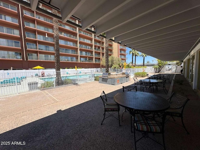 4750 N Central Ave Unit R3, Phoenix, AZ 85012 - view of patio / terrace with fence, a community pool, and outdoor dining space