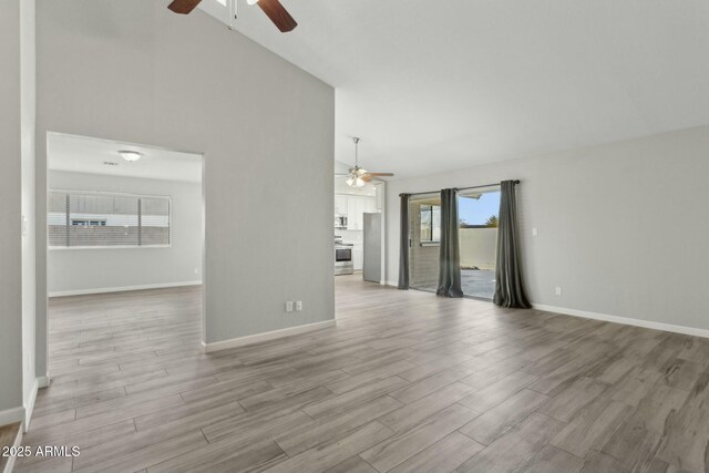 4634 W Aire Libre Ave, Glendale, AZ 85306 - unfurnished living room with light wood-type flooring, baseboards, high vaulted ceiling, and ceiling fan