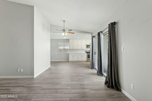 4634 W Aire Libre Ave, Glendale, AZ 85306 - unfurnished living room with light wood finished floors, a ceiling fan, baseboards, and vaulted ceiling