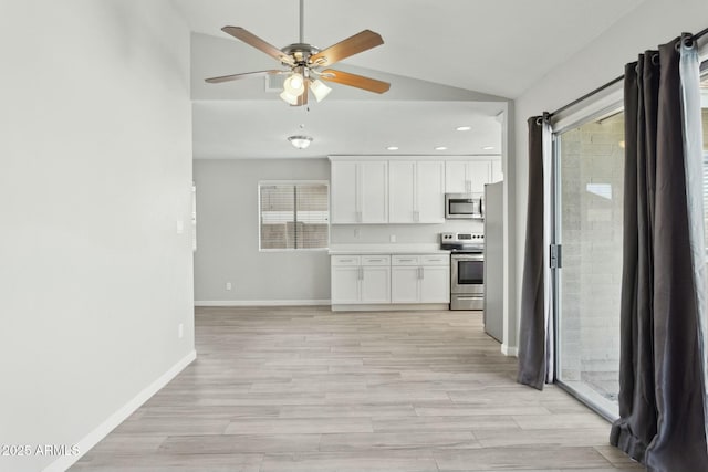4634 W Aire Libre Ave, Glendale, AZ 85306 - kitchen featuring baseboards, lofted ceiling, appliances with stainless steel finishes, light wood-style floors, and white cabinets