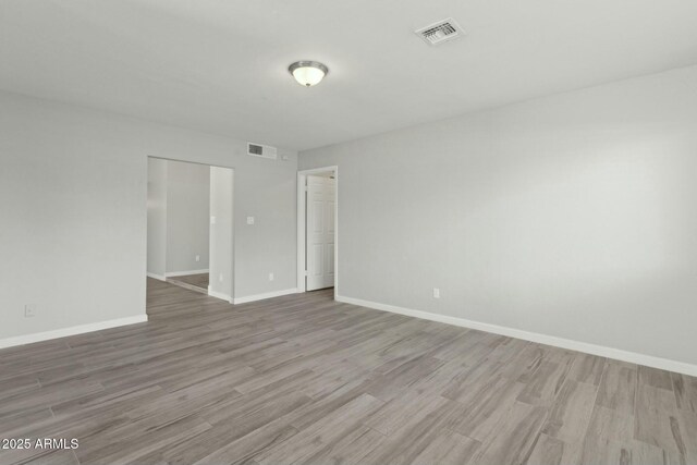 4634 W Aire Libre Ave, Glendale, AZ 85306 - empty room with wood finished floors, visible vents, and baseboards