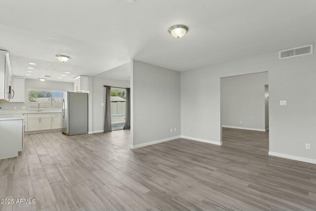 4634 W Aire Libre Ave, Glendale, AZ 85306 - unfurnished living room with a wealth of natural light, visible vents, and light wood-type flooring