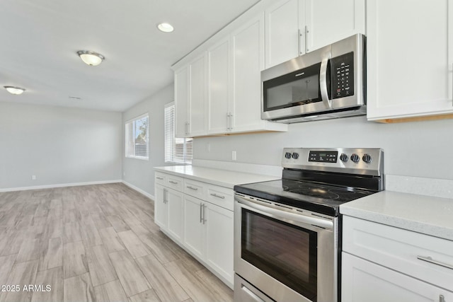 4634 W Aire Libre Ave, Glendale, AZ 85306 - kitchen featuring baseboards, light wood finished floors, light countertops, white cabinets, and appliances with stainless steel finishes