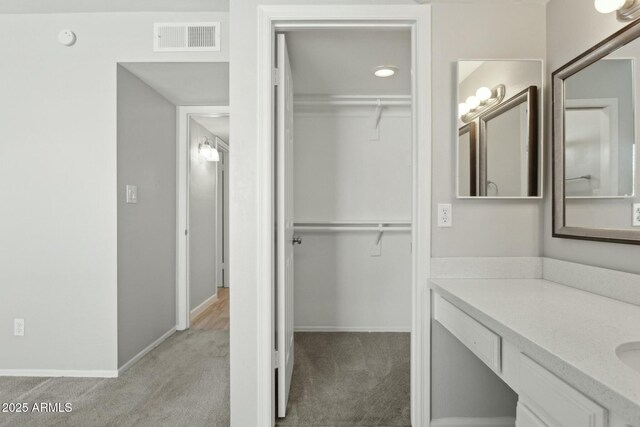 4634 W Aire Libre Ave, Glendale, AZ 85306 - bathroom featuring visible vents, baseboards, a spacious closet, and vanity