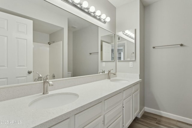 4634 W Aire Libre Ave, Glendale, AZ 85306 - bathroom featuring toilet, wood finished floors, baseboards, and a sink