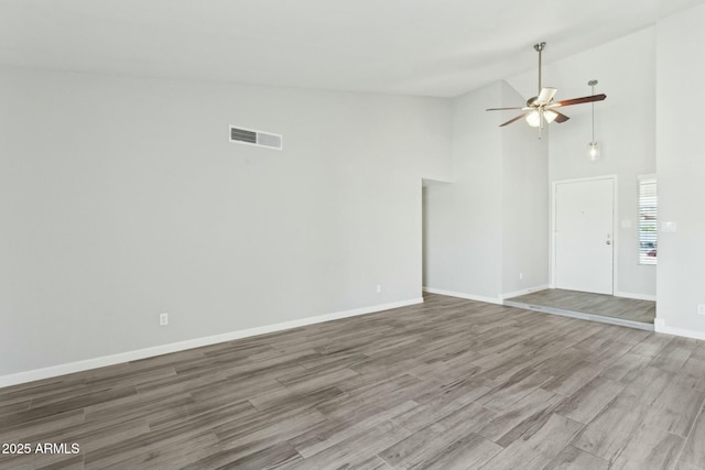 4634 W Aire Libre Ave, Glendale, AZ 85306 - unfurnished room with a ceiling fan, wood finished floors, visible vents, high vaulted ceiling, and baseboards