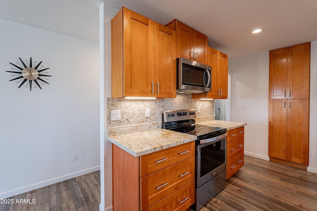 kitchen featuring backsplash, light stone counters, dark hardwood / wood-style flooring, and stainless steel appliances