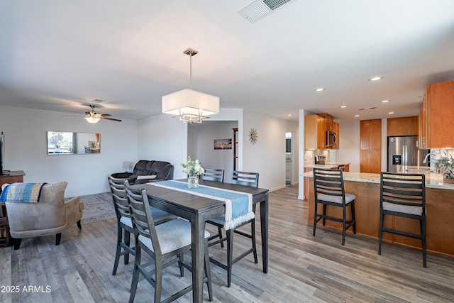 dining space with hardwood / wood-style floors, ceiling fan, and sink