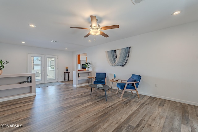 living area with french doors, ceiling fan, and wood-type flooring