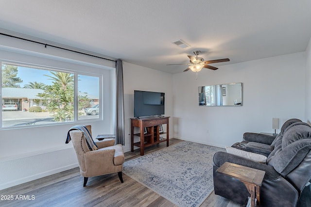 living room featuring a wealth of natural light, ceiling fan, and wood-type flooring