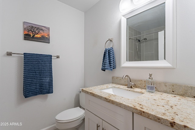 bathroom featuring vanity, toilet, and tiled shower