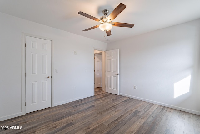 unfurnished bedroom with ceiling fan and dark wood-type flooring