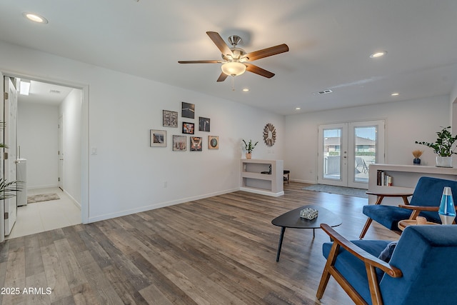 living room with ceiling fan, light wood-type flooring, and french doors