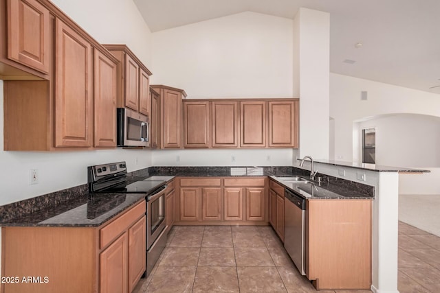 kitchen with stainless steel appliances, a peninsula, high vaulted ceiling, and dark stone countertops