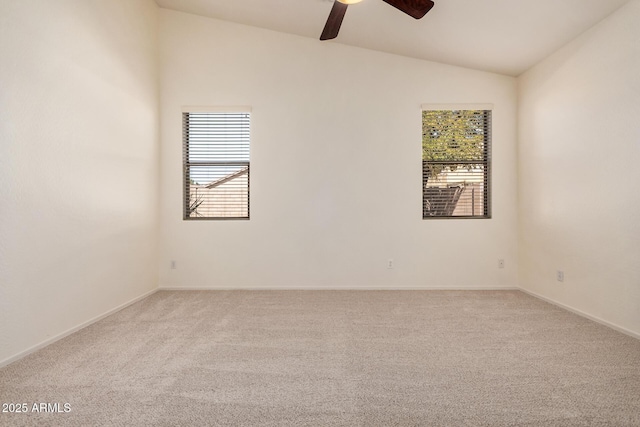 carpeted empty room featuring lofted ceiling, a ceiling fan, and baseboards