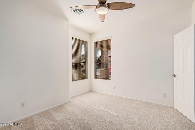 unfurnished room with baseboards, visible vents, ceiling fan, and light colored carpet