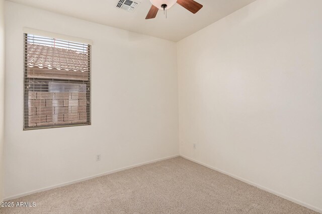 spare room featuring carpet floors, visible vents, a ceiling fan, and baseboards