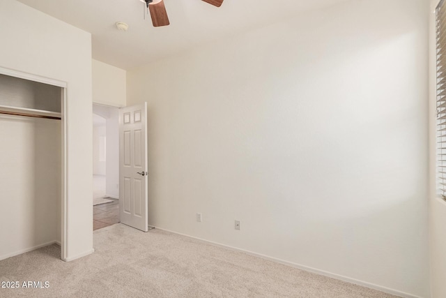 unfurnished bedroom with baseboards, light carpet, ceiling fan, and a closet