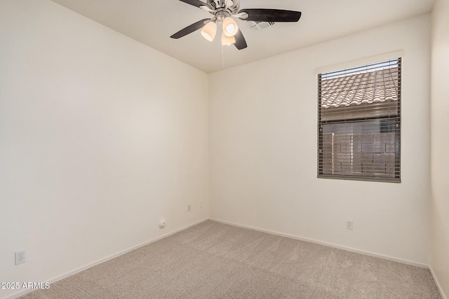 unfurnished room featuring baseboards, light colored carpet, and ceiling fan