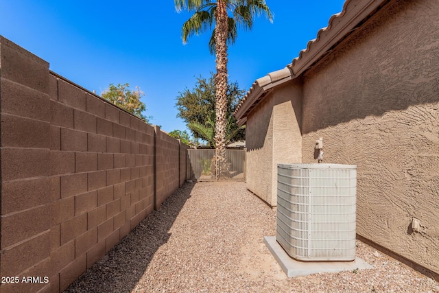 view of property exterior with central air condition unit, a tiled roof, a fenced backyard, and stucco siding