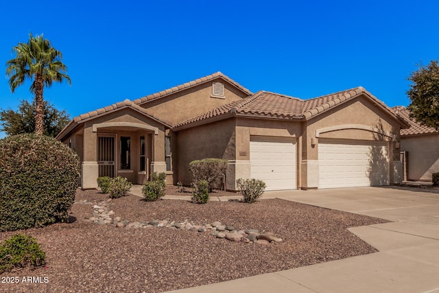 view of front of home with a tiled roof, an attached garage, concrete driveway, and stucco siding