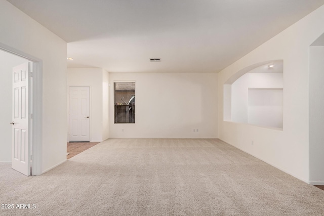 carpeted empty room with baseboards and visible vents