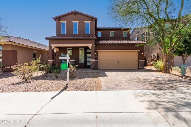 view of front facade featuring a tiled roof, decorative driveway, a garage, and stucco siding