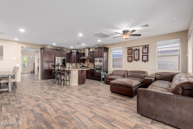 living room with plenty of natural light, ceiling fan, and light hardwood / wood-style floors