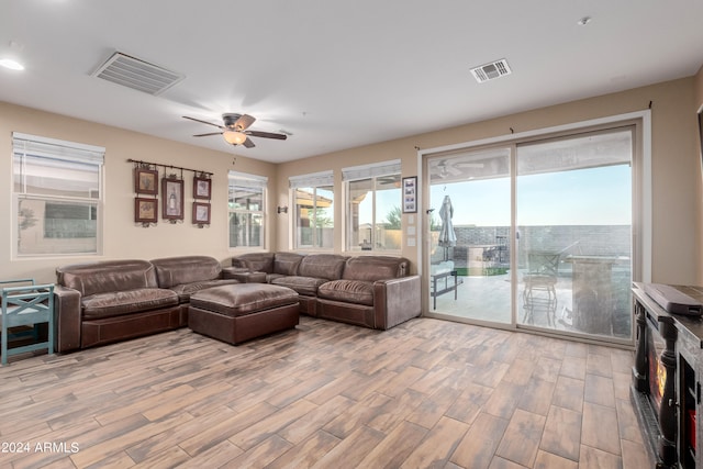 living room with light wood-type flooring and ceiling fan