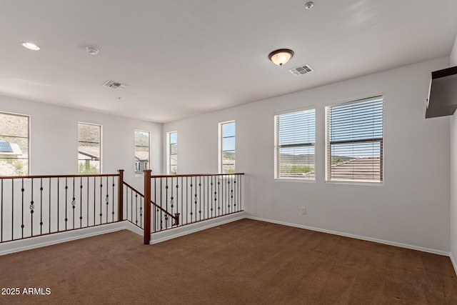 carpeted spare room featuring recessed lighting, baseboards, and visible vents