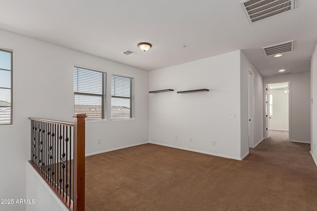 empty room featuring carpet and visible vents