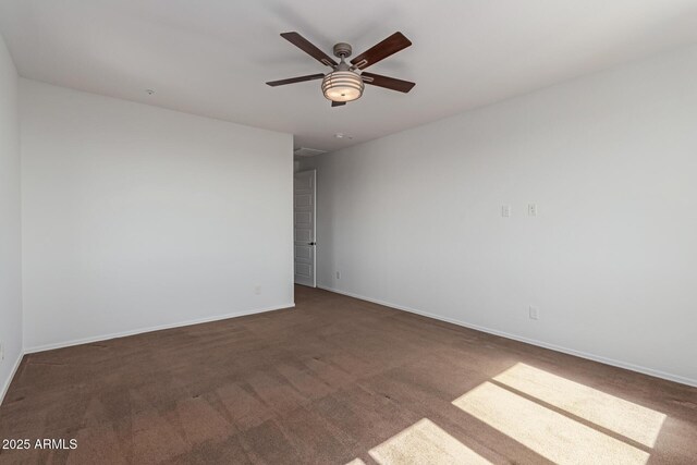 carpeted empty room with baseboards and a ceiling fan