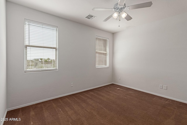 unfurnished room featuring a ceiling fan, baseboards, visible vents, and dark carpet