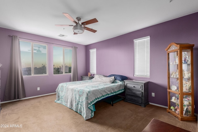 carpeted bedroom with multiple windows and ceiling fan