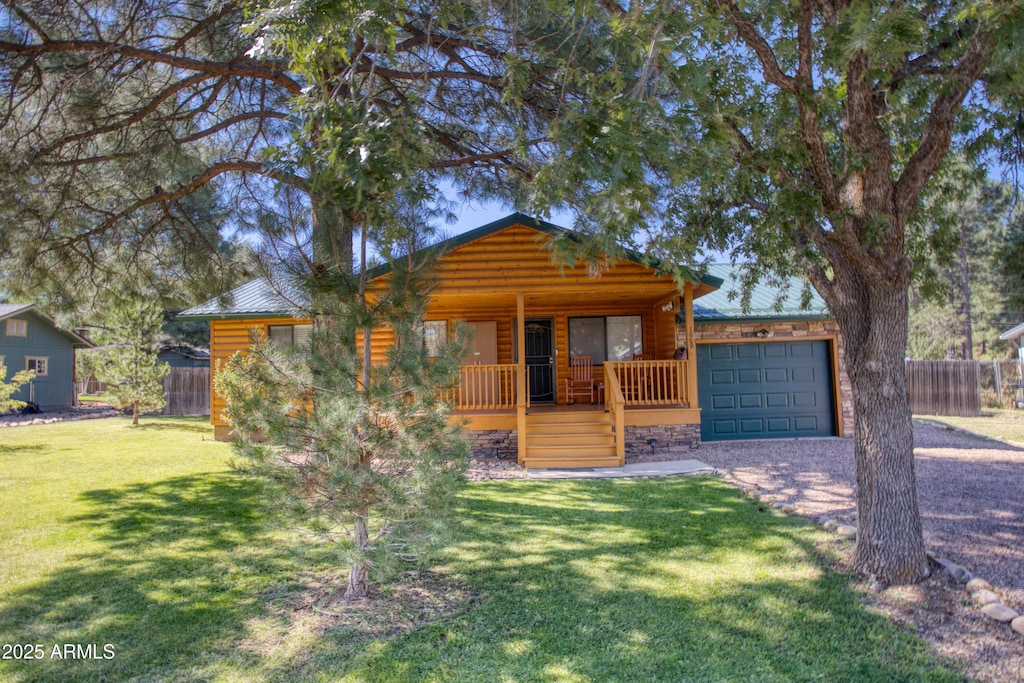 log-style house with a front yard, covered porch, and a garage