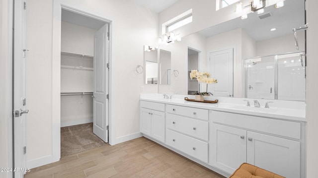 bathroom with vanity, a shower with shower door, and wood-type flooring