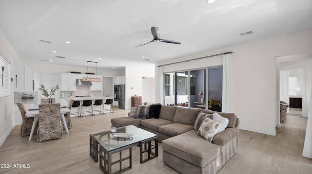 living room featuring ceiling fan and light hardwood / wood-style flooring