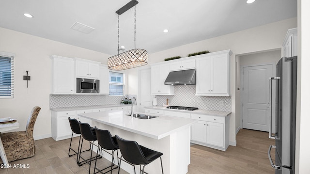 kitchen featuring sink, white cabinets, a center island with sink, and appliances with stainless steel finishes