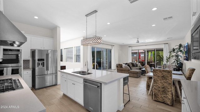 kitchen featuring a kitchen island with sink, white cabinets, sink, stainless steel appliances, and extractor fan