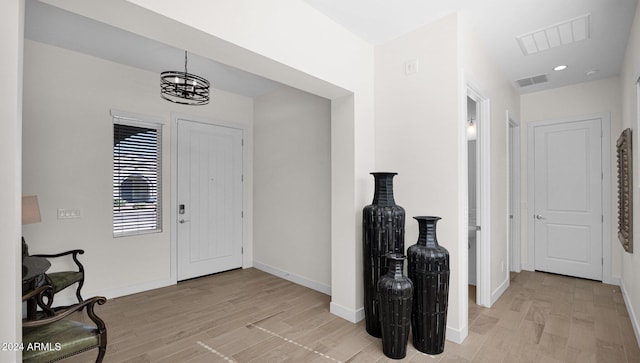 foyer featuring a notable chandelier and light hardwood / wood-style floors