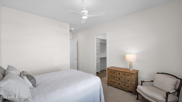 carpeted bedroom featuring a closet, a spacious closet, and ceiling fan