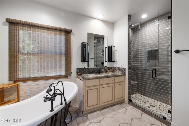 bathroom featuring a stall shower, recessed lighting, a washtub, and vanity