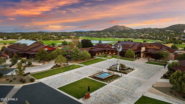 aerial view at dusk with a residential view, view of golf course, and a water and mountain view
