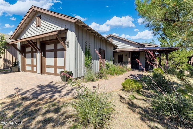 view of front of home with decorative driveway, an attached garage, and board and batten siding
