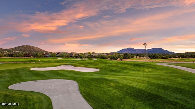 view of home's community featuring a mountain view, a yard, and view of golf course